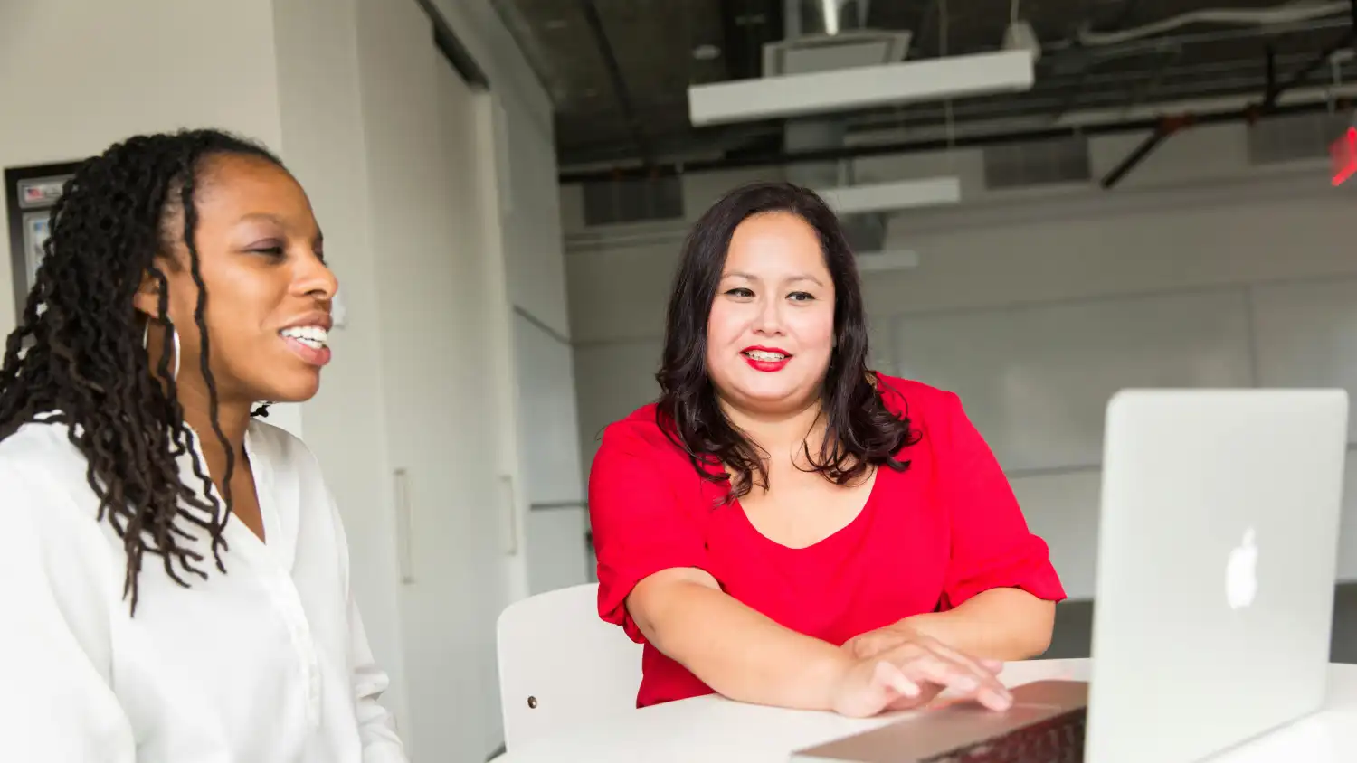 Two women looking at a laptop screen together